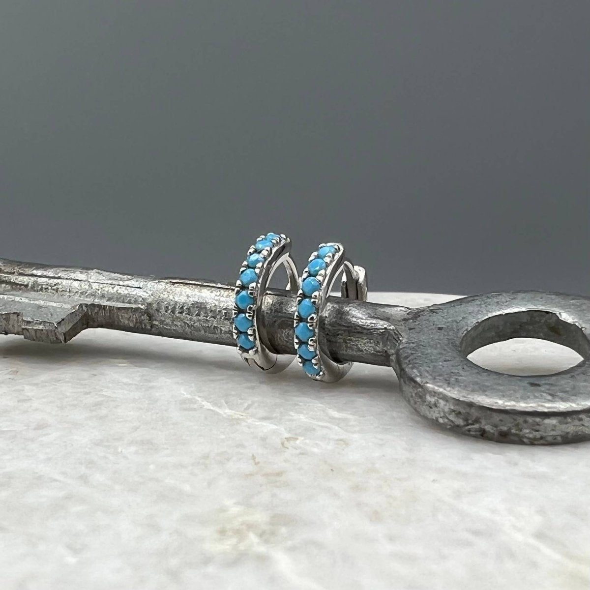 Turquoise CZ Huggie Hoops: Sterling Silver by Something Silver